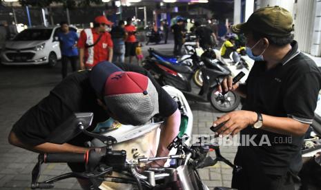 Seorang teknisi memeriksa tangki bensin motor yang mogok usai mengisi bahan bakar di salah satu pom bensin di Jalan Ir Juanda, Bekasi, Jawa Barat, Selasa (26/3/2024) dini hari. Menurut keterangan konsumen yang terdampak sebanyak puluhan kendaraan bermotor mogok usai isi bensin dan pihak dari pom bensin mengganti 100 persen biaya kerusakan kendaraan yang rusak. 