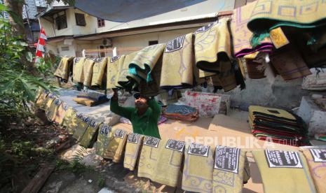 Pekerja menjemur sajadah di industri rumahan pembuatan sablon sajadah, kawasan Kebon Melati, Jakarta, Rabu (1/9/2021). Kementerian Koperasi dan Usaha Kecil Menengah (UKM) mencatat realisasi penyaluran Bantuan Produktif Usaha Mikro (BPUM) atau BLT UMKM di 2021 telah mencapai Rp 14,21 triliun atau setara 92,35 persen dari total anggaran sebesar Rp 15,36 triliun. 