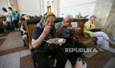 Pengungsi dari Mykolayiv menerima bantuan makanan kemanusiaan saat mereka menunggu di stasiun kereta api di Odesa, Ukraina barat daya, 02 Juni 2022, sebelum melakukan perjalanan ke barat Ukraina atau negara lain. Pihak berwenang Mykolayiv meminta penduduk setempat untuk meninggalkan beberapa wilayah kota di tengah invasi Rusia. 