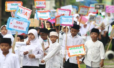 Pelajar SD Negeri Tempurejo 1 membawa poster saat mengikuti pawai memperingati Isra Miraj di Kota Kediri, Jawa Timur, Kamis (23/1/2025). 