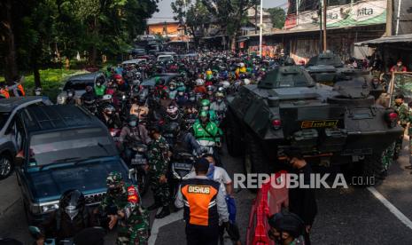 Petugas gabungan mengimbau pengendara untuk memutar balik saat melewati posko penyekatan pada jam berangkat kerja di Jalan Lenteng Agung, Jakarta Selatan, Senin (5/7). Penyekatan pada hari ketiga Pemberlakuan Pembatasan Kegiatan Masyarakat (PPKM) Darurat tersebut menyebabkan kemacetan sepanjang 2 kilometer. Republika/Thoudy Badai