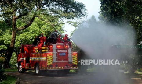 Petugas pemadam kebakaran melakukan penyemprotan disinfektan 