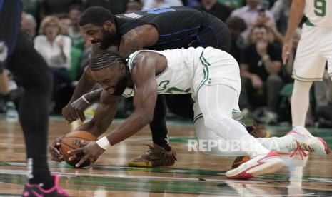 Guard Boston Celtics Jaylen Brown berebut bola dengan pemain Dallas Mavericks Kyrie Irving pada Game 1 Final NBA bola basket di Boston, Jumat (7/6/2024) WIB. Boston Celtics menang telak atas Dallas Mavericks dengan skor 107-89. Jaylen Brown menjadi pencetak poin terbanyak untuk Celtics dengan torehan 22 poin.