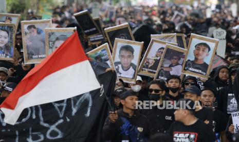 Suporter Arema FC (Aremania) membawa foto korban tragedi Kanjuruhan saat berunjuk rasa memperingati 40 Hari Tragedi Kanjuruhan di Jalan Basuki Rahmat, Malang, Jawa Timur, Kamis (10/11/2022). Unjuk rasa yang diikuti ribuan Aremania tersebut menuntut pemerintah dan aparat penegak hukum menangkap serta mengadili seluruh pelaku yang terlibat dalam kasus tersebut. 