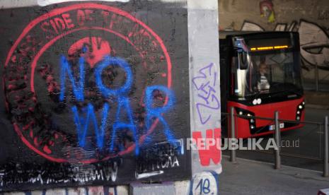 Bus melintasi logo Wagner yang dicorat-coret dengan kalimat 'No War'.