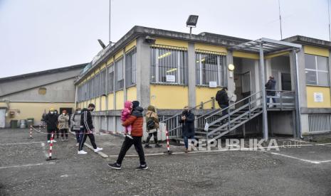 Orang-orang berbaris untuk pengujian ketika tentara tentara Italia mendirikan tenda yang akan berfungsi sebagai pusat pengujian COVID-19 di Codogno, Lombardy, Italia Utara, beberapa waktu lalu.