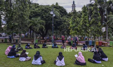 Sejumlah santri Al-Hasan membaca Al Quran metode Qiroati atau dibaca secara langsung tanpa dieja, di Alun-alun Kabupaten Ciamis, Jawa Barat, Jumat (18/12/2020). Kegiatan membaca Al Quran di ruang terbuka dengan menerapkan pratokol kesehatan itu, untuk menghilangkan kejenuhan santri mengaji di Pondok Pesantren di tengah Pandemi COVID-19. 