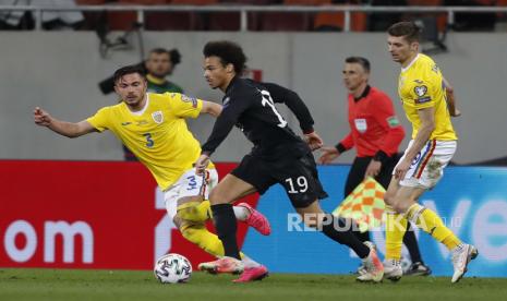 Leroy Sane (tengah) Jerman beraksi melawan Alin Tosca (kiri) Rumania selama pertandingan sepak bola kualifikasi Piala Dunia FIFA 2022 antara Rumania dan Jerman di Bucharest, Rumania, 28 Maret 2021.