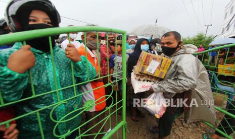 Seorang warga membawa paket sembako bansos. Dana parkir anggaran daerah di perbankan yang mencapai Rp 252 triliun seharusnya bisa dimanfaatkan pemda untuk alokasi kesehatan atau untuk meningkatkan kesejahteraan masyarakat terdampak Covid-19 secara ekonomi.