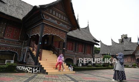 Pengunjung berfoto di area anjungan Sumatra Barat di Taman Mini Indonesia Indah (TMII), Jakarta Timur, Ahad (12/9/2021). 