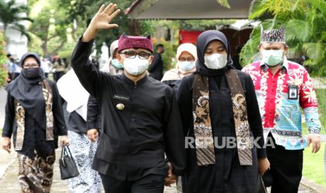 Bupati Banyuwangi Abdullah Azwar Anas (kedua kiri) bersama istri Ipuk Fiestiandani Azwar Anas (kedua kanan) melambaikan tangan usai mengikuti upacara Hari Jadi ke-249 Banyuwangi di Pendopo Banyuwangi, Jawa Timur, Jumat (18/12/2020). Kabupaten Banyuwangi merayakan hari jadi di masa pandemi dengan menggelar upacara yang hanya diikuti 50 peserta dari Aparatur Sipil Negara (ASN) dengan menerapkan protokol COVID-19. 