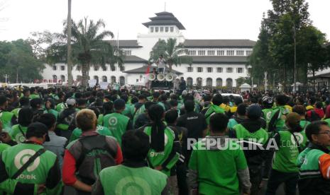 Ribuan pengendara ojek online (ojol) dan taksi online melakukan aksi di depan Gedung Sate Jalan Diponegoro, Kota Bandung, Selasa (25/6/2024). Mereka menolak tarif murah dan meminta agar pemerintah mendorong perusahaan aplikasi menaikkan tarif bagi ojol sesuai dengan peraturan pemerintah. Mereka mengatakan pengemudi taksi online hanya menerima Rp 2.500 per kilometer dari tarif bawah sebesar Rp 3.500. Sedangkan pengendara ojek online hanya menerima Rp 1.500 per kilometer dari tarif bawah 2.500.