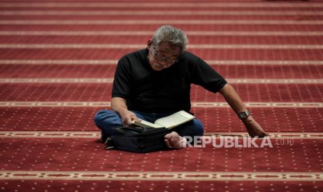 Jamaah membaca Alquran saat menunggu waktu berbuka puasa di Masjid Istiqlal, Jakarta, Rabu (5/4/2023).