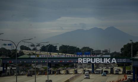 Sejumlah kendaraan keluar dari Gerbang Tol Cilandak Utama dengan latar belakang Gunung Gede Pangrango di Jakarta.