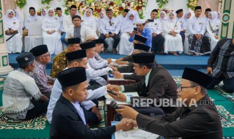 Sejumlah calon pengantin pria mengucapkan ijab qobul saat mengikuti Nikah Maulid di Gedung Kanzus Sholawat, Pekalongan, Jawa Tengah, Jumat (20/10/2023). Nikah massal yang diselenggarakan gratis oleh Majelis Kanzus Sholawat dalam rangka Peringatan Maulid Nabi Muhammad SAW 1445 H/2023 M itu diikuti 23 pasangan pengantin.  