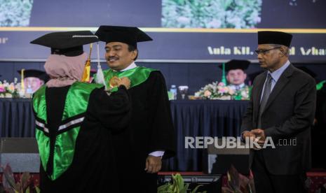 Ketua Senat UMJ Masyitoh Chusnan (kiri) menyematkan lencana kepada Rektor UMJ Mamun Murod disaksikan Ketua Umum PP Muhammadiyah Haedar Nashir saat prosesi pengukuhan sebagai Guru Besar Bidang Ilmu Politik di Universitas Muhammadiyah Jakarta, Tangerang Selatan, Banten, Kamis (9/11/2023). 