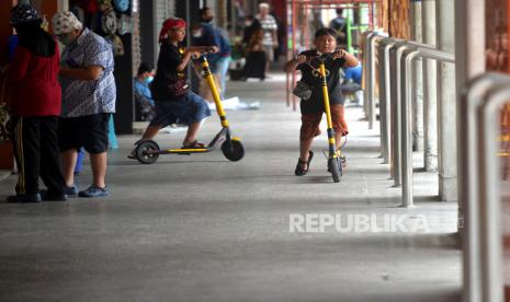 Wisatawan bermain skuter listrik di teras pertokoan Malioboro, Yogyakarta, Rabu (23/3/2022). Gubernur DIY Sri Sultan HB X menegaskan becak motor atau bentor dan skuter listrik tak boleh beroperasi di kawasan Malioboro Jogja. Menurut Sultan, kendaraan yang boleh beroperasi di Malioboro adalah becak kayuh dan andong sebagai angkutan tradisional yang sudah diatur di Perda DIY. DIY sudah memiliki Perda No.5/2016 tentang Moda Transportasi Tradisional Becak dan Andong. Sultan meminta Pemkot Jogja segera membereskan skuter listrik dan bentor yang masih berada di kawasan Malioboro.