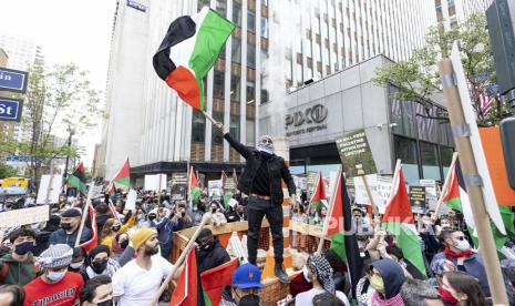 Pengunjuk rasa mengibarkan bendera Palestina selama demonstrasi pro-Palestina di dekat Konsulat Jenderal Israel di New York, New York, AS, 11 Mei 2021. 