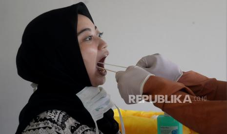 Tenaga medis mengambil sampel lendir pasien dari bilik swab test chamber saat tes swab massal di Rumah Sakit Universitas Indonesia (RSUI), Depok, Jawa Barat, Selasa (2/6). Dua rukun warga (RW) di Kelurahan Tanah Baru, Kota Depok masuk zona merah Covid-19.