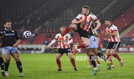 John Lundstram dari Sheffield United, kanan, menghalau  bola di depan John McGinn dari Aston Villa, kiri, pada laga  Liga Premier Inggris antara Sheffield United dan Aston Villa di Stadion Bramall Lane di Sheffield, Inggris, Kamis, (4/3) dini hari WIB.