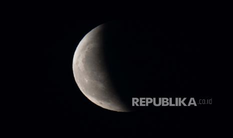 Bayangan bumi sebagian mengaburkan bulan saat muncul dari balik awan selama gerhana bulan di langit di atas Beijing pada hari Rabu, 26 Mei 2021.