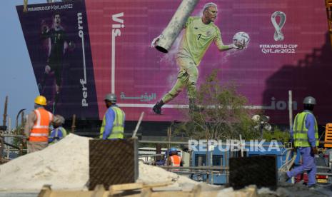 Papan reklame bergambar kiper Kosta Rika Keylor Navas dan kiper Belgia Thibaut Courtois ditampilkan di latar belakang saat para pekerja bekerja di sebuah jalan di Doha, Qatar, Sabtu, 12 November 2022. Persiapan terakhir sedang dilakukan untuk Piala Dunia sepak bola, yang dimulai pada 20 November saat Qatar menghadapi Ekuador.