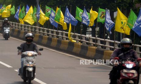 Kendaraan melintasi jembatan yang terpasang bendera partai politik. Pemerintah berencana menaikkan dana bantuan partai politik dari Rp 1.000 per suara menjadi Rp 3.000.