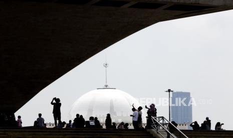 Pengunjung saat berwisata di Monumen Nasional, Jakarta, Sabtu (13/4/2024). Bolehkah umat Islam menjamak sholat ketika sedang berwisata?