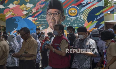 Sejumlah tenaga pendidikan mengantre mendaftar vaksinasi COVID-19 di SMA Negeri 70 Jakarta, Jakarta, Rabu (24/2/2021). Pemerintah memulai tahap vaksinasi untuk guru, tenaga kependidikan, dan dosen dengan target sebanyak 5.057.582 orang se-Indonesia. 