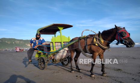 Andong menunggu penumpang di Pantai Parangtriris,  Yogyakarta, Kamis (25/6). Sepekan terakhir warga sudah mulai mengunjungi kembali mengunjungi Pantai Parangtritis. Hampir tiga bulan Pantai Parangtritis tidak dikunjungi wisatawan.