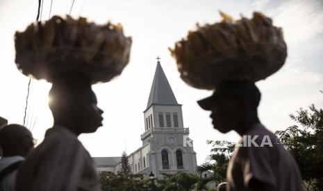  Dengan latar belakang gereja Katolik Santo Petrus, pedagang kaki lima menunggu pelanggan di luar sekolah Nasional Lycée di distrik Petion Ville, Port-au-Prince, Haiti, Senin, 27 September 2021. Tiga orang misionaris yang diculik di Haiti bulan Oktober lalu telah dibebaskan.