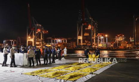 Petugas kepolisian Indonesia Disaster Victim Identification (DVI) membawa kantong jenazah berisi jenazah yang ditemukan di dekat lokasi jatuhnya pesawat Sriwijaya Air penerbangan SJ 182 di perairan Jakarta di pelabuhan Tanjung Priok di Jakarta, Indonesia, 14 Januari 2021. Penerbangan Sriwijaya Air SJ182 jatuh ke laut di lepas pantai Jakarta pada 09 Januari 2021 tak lama setelah lepas landas dari Bandara Internasional Jakarta saat dalam perjalanan ke Pontianak di provinsi Kalimantan Barat.