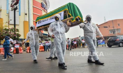 Sejumlah anggota Kepolisian membawa keranda mayat saat sosialisasi penggunaan masker di Jalan RE Martadinata, Cikarang, Kabupaten Bekasi, Jawa Barat, Kamis (10/9/2020). Kegiatan tersebut untuk memberikan kesadaran kepada masyarakat tentang pentingnya menggunakan masker untuk pencegahan virus COVID-19. 