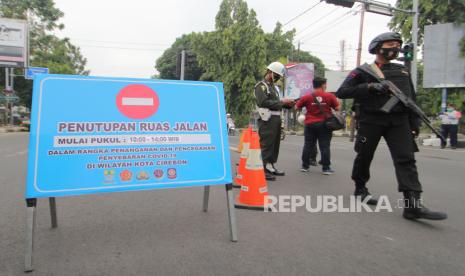 Petugas Dinas Perhubungan dan personel Brimob berjaga di ruas jalan Siliwangi, Kota Cirebon, Jawa Barat saat Pembatasan Aktivitas Masyarakat. Ilustrasi