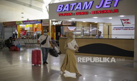 Calon penumpang berjalan melintas di depan konter tiket kapal ferry di Pelabuhan Domestik Sekupang, Batam, Kepulauan Riau. ilustrasi