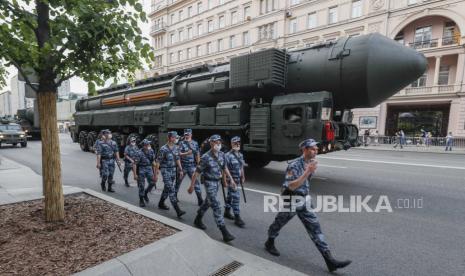  Polisi Rusia yang mengenakan topeng pelindung berbaris di depan rudal nuklir strategis Rusia RS-24 Yars yang bergerak di sepanjang jalan sebelum latihan malam parade militer Victory di Lapangan Merah, di Moskow, Rusia, 17 Juni 2020. Militer parade yang menandai peringatan 75 tahun kemenangan atas Nazi Jerman dalam Perang Dunia II akan berlangsung di Lapangan Merah pada 24 Juni 2020.