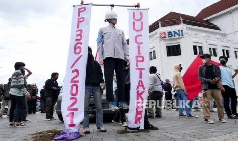 Peserta aksi dari Majelis Pekerja Buruh Indonesia (MPBI) membawa manekin pekerja digantung saat aksi di Titik Nol Yogyakarta, Rabu (24/11). Dalam aksi ini mereka menuntut penetapan UMK DIY 2022 berdasarkan kebutuhan hidup layak. Selain itu menuntut pencabutan UU Cipta Kerja 11/2020 beserta PP turunannya.