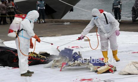  Seorang pekerja menyemprotkan disinfektan ke kantong jenazah yang berisi jenazah penumpang Sriwijaya Air Penerbangan 182 yang jatuh di perairan Pulau Jawa, di Pelabuhan Tanjung Priok di Jakarta, Indonesia, Minggu, 10 Januari 2021. Tim penyelamat Indonesia mencabut bagian tubuh, Potongan pakaian dan potongan logam dari Laut Jawa Minggu pagi, sehari setelah Boeing 737-500 dengan puluhan orang di dalamnya jatuh tak lama setelah lepas landas dari Jakarta, kata para pejabat.