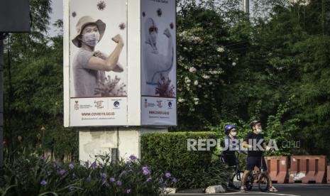 Pesepeda berhenti di dekat baliho sosialisasi manfaat vaksinasi di Jalan Asia Afrika, Senayan, Jakarta, Minggu (22/11/2020). Presiden Joko Widodo memperkirakan pemberian vaksin COVID-19 dapat dilakukan pada akhir Desember 2020 atau awal Januari 2021, tergantung dari datangnya vaksin dan proses persiapan yang dilakukan di Indonesia. 