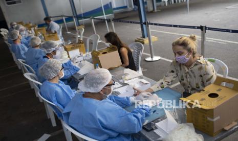 Petugas kesehatan mengambil sampel darah penduduk di lokasi pengujian COVID-19 di tengah pandemi coronavirus baru di Rio de Janeiro, Brasil, Jumat, 17 Juli 2020. 