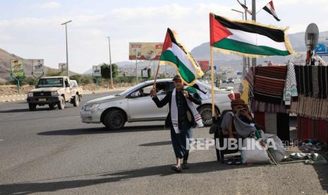 Warga Yaman memajang bendera dan syal Palestina untuk dijual di jalan yang dipenuhi spanduk bergambar potret mendiang pejuang Houthi yang tewas dalam konflik Yaman, di Sana'a, Yaman, 02 November 2023.