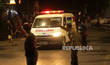 Mobil ambulans melintas di antara demonstran saat aksi unjuk rasa menolak Undang-Undang Cipta Kerja (UU Omnibus Law) yang berujung ricuh di Jalan Sultan Alauddin, Makassar, Sulawesi Selatan, Kamis (8/10/2020) malam. Bentrokan terjadi saat polisi berusaha membubarkan pengunjuk rasa yang masih bertahan hingga malam hari. 