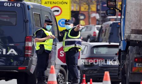 Seorang petugas polisi Prancis, kiri, dan Spanyol berbicara di perbatasan Prancis-Spanyol di Behobie, Prancis barat daya, Selasa, 30 Maret 2021. 