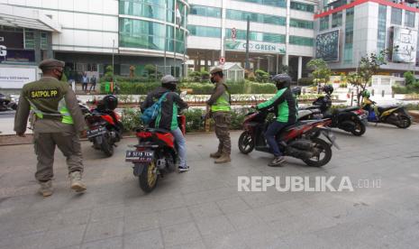 Petugas Satpol PP Provinsi DKI Jakarta menertibkan ojeg online yang berkumpul di area Jalan Prof Dr Satrio, Jakarta,  Senin (20/4/2020). Penertiban tersebut terkait pelaksanaan Pembatasan Sosial Berskala Besar(PSBB) di wilayah Jakarta dan memutus rantai penyebaran COVID 19