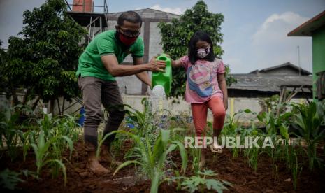 Petugas mendampingi anak saat praktik berkebun di area edukasi pengolahan sampah Padepokan Restu Bumi, Ciracas, Jakarta, Sabtu (21/11). Dinas Lingkungan Hidup dan Kehutanan (LHK) Jakarta Timur mengadakan program edukasi urban farming seperti penanaman padi, budidaya maggot, berkebun dan berternak. Kegiatan itu juga memperingati Hari Pohon Sedunia yang jatuh tiap tanggal 21 November. Republika/Thoudy Badai