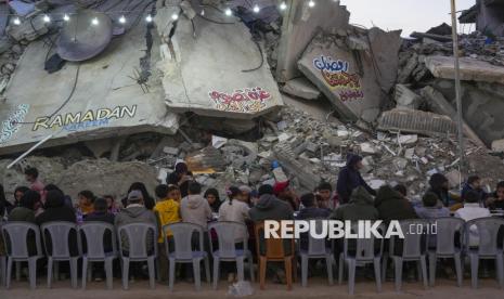 Warga Palestina berbuka puasa bersama diantara reruntuhan rumah dan bangunan di Rafah, Jalur Gaza selatan, Sabtu (1/3/2025). Pasca gencatan senjata, warga Palestina menjalani bulan suci Ramadhan dengan lebih baik jika dibandingkan tahun sebelumnya. Meski hidup ditengah kondisi kota yang hancur, namun pada Ramadhan tahun ini warga Palestina di Gaza bisa melakukan buka puasa dan ibadah Ramadhan bersama dengan tenang. 