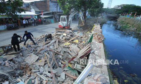 Ekskavator mini membatu merobohkan bangunan yang berdiri di bantaran sungai saat pelaksanaan program normalisasi dan penataan Sungai Cidurian, di kawasan Kelurahan Cisaranten Endah, Kota Bandung, Selasa (3/8). Pemerintah Kota Bandung bersama Balai Besar Wilayah Sungai (BBWS) Citarum rencananya akan membangun kolam retensi dan ruang terbuka hijau (RTH) di kawasan tersebut sebagai salah satu upaya mengatasi banjir.