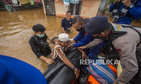  Tim penyelamat membantu seorang pria lanjut usia untuk naik ke perahu mereka di sebuah desa yang banjir di Banjar, Kalimantan Selatan di Pulau Kalimantan, Indonesia, pada foto Sabtu 16 Januari 2021 ini. Ribuan orang telah dievakuasi dan sejumlah lainnya tewas dalam beberapa hari terakhir akibat banjir di pulau Kalimantan, Indonesia, kata para pejabat Minggu.