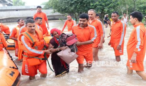 Personel Pasukan Tanggap Bencana Nasional (NDRF) menyelamatkan penduduk dari daerah banjir di dataran rendah sungai Yamuna di New Delhi, India, (13/7/2023).