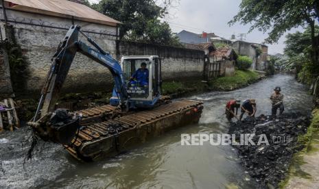 Petugas mengoperasikan alat berat saat melakukan pengerukan sungai (ilustrasi)